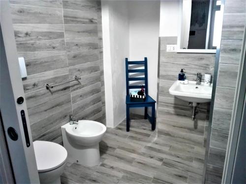 een badkamer met een toilet, een wastafel en een blauwe stoel bij Only for two Giumbabulla in Ragusa