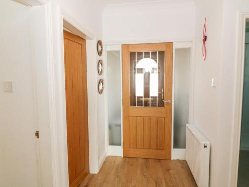 a hallway with a wooden door in a house at Tarnacrye in Annan