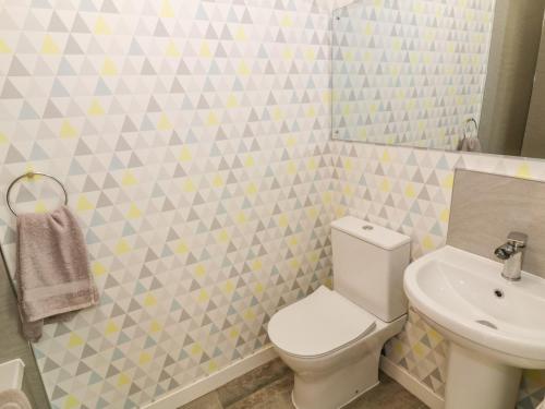 a bathroom with a white toilet and a sink at Tarnacrye in Annan