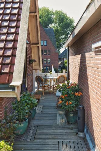 an outdoor deck with a table and chairs and plants at Com-In in Alkmaar