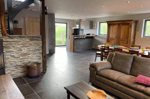 uma sala de estar com um sofá e uma lareira de pedra em Valgrange em Tenneville