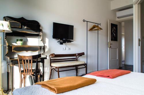 a bedroom with a bed and a television and chairs at Eleventh Floor Suites in Cagliari