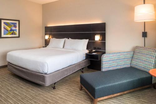 a hotel room with a bed and a chair at Holiday Inn Express Jacksonville East by IHG in Jacksonville
