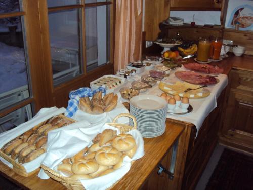 a table with various types of bread and pastries on it at Pension Sursilva in Gargellen