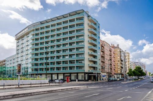 ein hohes Glasgebäude in einer Stadtstraße in der Unterkunft Hotel Roma in Lissabon