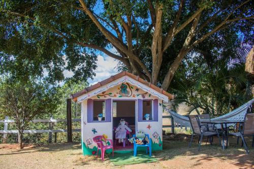 a small pretend play house in front of a tree at Pousada Sonho Meu in Itanhandu