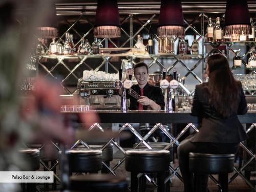 a man and a woman sitting at a bar at Grischa - Das Hotel Davos in Davos