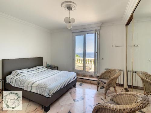 a bedroom with a bed and two chairs and a window at Seaview villa Marlau in Macinaggio