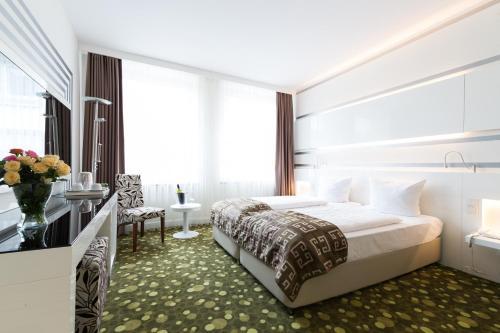 a hotel room with a large bed and a window at Hotel Bayer's in Munich