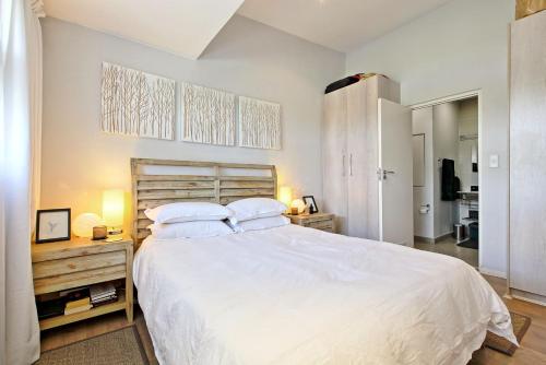1 dormitorio con 1 cama blanca grande y 2 almohadas en The Space, en Johannesburgo