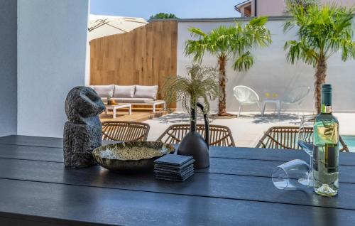a table with a bottle of wine and a bowl of food at Superb Design Villa Medulin in Medulin