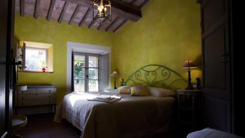 聖卡夏諾德伊巴尼的住宿－Casa Fabbrini Agriturismo，一间设有床铺的卧室,位于一个拥有绿色墙壁的房间