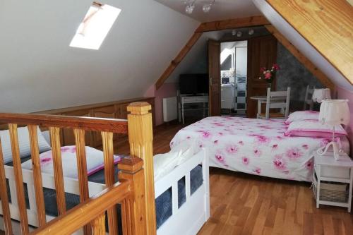 a attic bedroom with a bed and a staircase at les alouettes in Leschelles