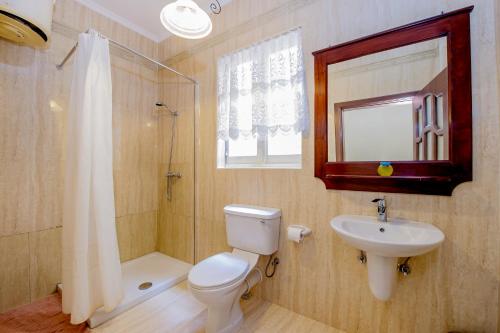 y baño con aseo, lavabo y ducha. en Lantern apartments, en Marsalforn