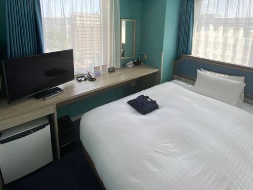 a hotel room with a large bed with a flat screen tv at Hotel Wing International Select Kumamoto in Kumamoto
