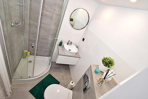 łazienka z toaletą, umywalką i prysznicem w obiekcie Apartament nad Strugą w Toruniu