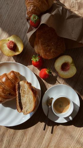 a table with a plate of bread and a cup of coffee at Apartmenthotel Ritterhof Suites & Breakfast in Schenna
