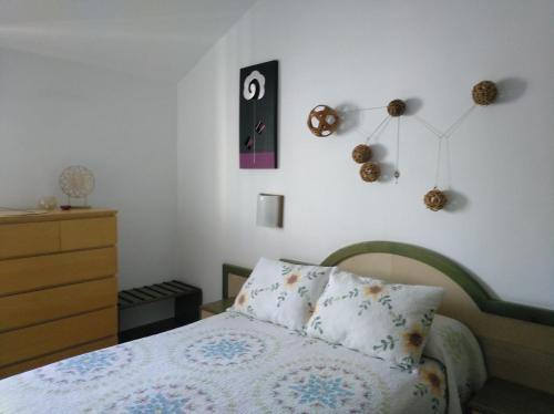 sypialnia z łóżkiem i zegarem na ścianie w obiekcie 2 Calle las Azucenas w mieście Playa del Aguila