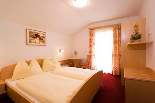 ein Hotelzimmer mit einem Bett und einem Fenster in der Unterkunft Kleinellmauhof in Großarl