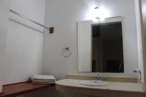 a bathroom with a sink and a large mirror at Hotel Gina in San Juan de los Lagos