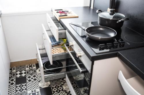 - une cuisine équipée d'une cuisinière avec une poêle dans l'établissement L'indigo - Hypercentre - 4 personnes, au Havre