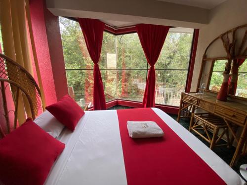 a red and white bed in a room with a window at Hotel Alameda in Orizaba