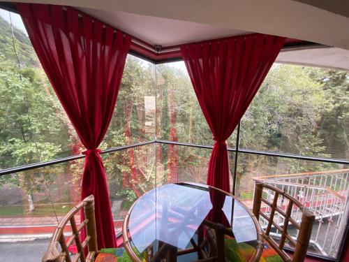 a window with red curtains and a glass table at Hotel Alameda in Orizaba