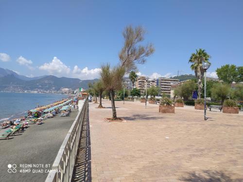 a group of people sitting on a sidewalk next to the beach at civico sei rooms in Salerno