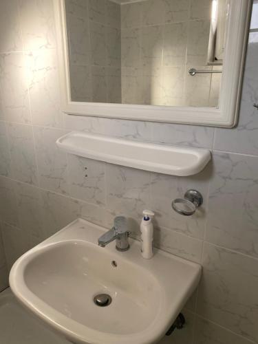 - białą umywalkę w łazience z lustrem w obiekcie Sindonia beach Apartment's w mieście Psari Forada