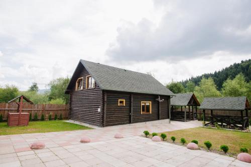 a small cabin in a yard with a patio at Рибничанка in Skhidnitsa