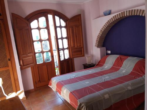 a bedroom with a bed and a large window at Casa Santa Ana in Lanjarón