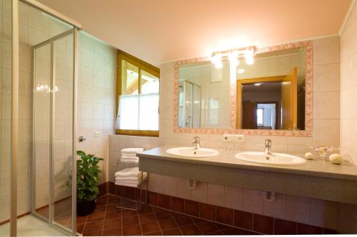 a bathroom with two sinks and a large mirror at Kleinellmauhof in Grossarl
