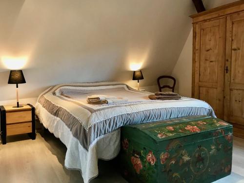 a bedroom with a large bed and a wooden cabinet at Gîte Par ci, Par là in Turckheim