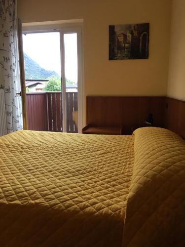 um quarto com uma cama grande e uma janela em Hotel Vezzano em Vezzano