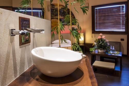 a bathroom with a large white bath tub on a counter at Hotel Motel K in Casei Gerola