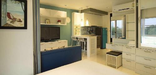 a kitchen with white cabinets and a blue wall at The Gallery Jomtien Beach Pattaya Duluxe Room By Dome in Jomtien Beach