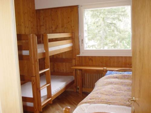 sypialnia z 2 łóżkami piętrowymi i oknem w obiekcie LE NEVADA CRANS-MONTANA vue a vous couper le soufle w mieście Crans-Montana