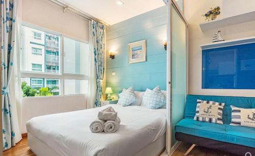 1 dormitorio con cama y pared azul en The trust huahin sky room condo pool view, en Hua Hin