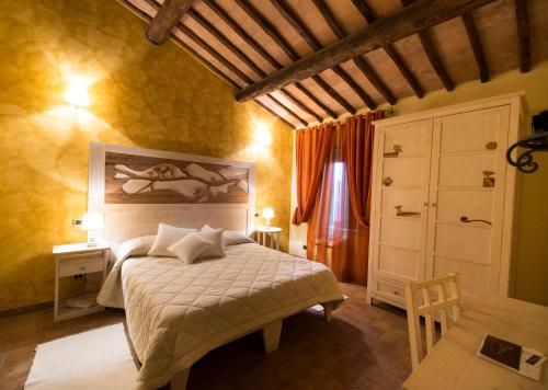 a bedroom with a bed with a painting on the wall at Borgo San Faustino Country Relais and Spa Orvieto in Orvieto