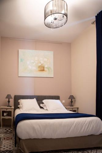 a bedroom with a bed and a chandelier at Hotel Galla Placidia in Narbonne