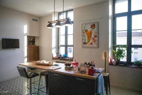 a kitchen with a island in a room with windows at Hotel Galla Placidia in Narbonne