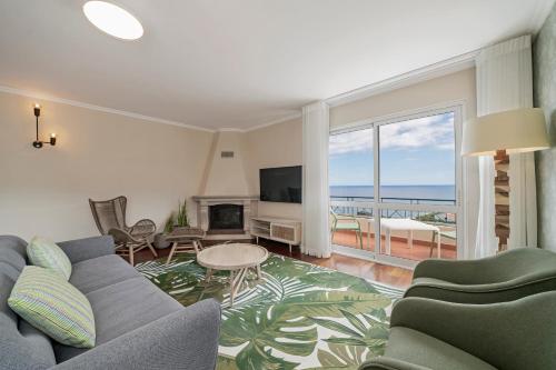 a living room with a couch and a television at Reis Magos V by An Island Apart in Caniço