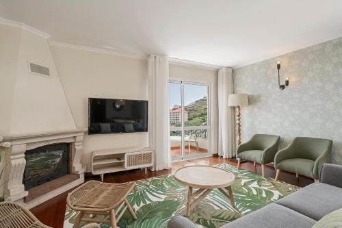 a living room with a fireplace and a tv at Reis Magos V by An Island Apart in Caniço