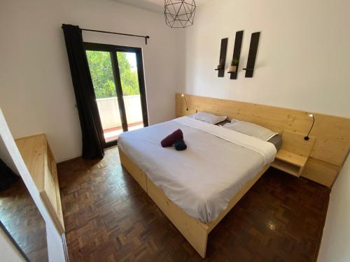 a bedroom with a bed with a wooden head board at Algarve Surf Hostel - Sagres in Sagres