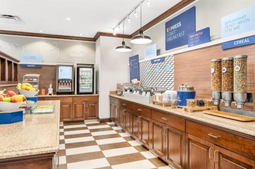 a kitchen with wooden cabinets and a checkered floor at Holiday Inn Express & Suites Wilmington-Newark by IHG in Newark