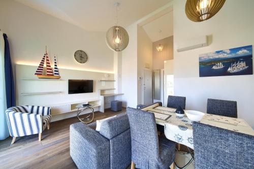 a living room with a table and chairs and a television at Villa Lungomare in Malinska
