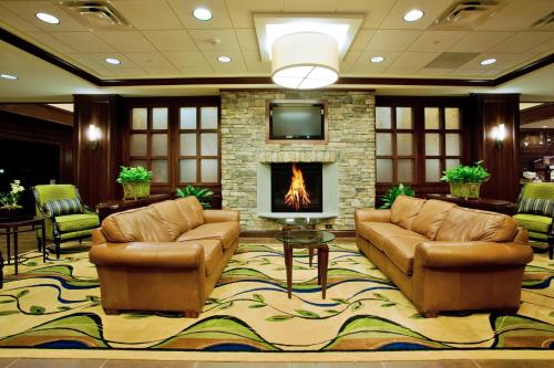 a living room with two couches and a fireplace at Holiday Inn Express & Suites Wilmington-Newark, an IHG Hotel in Newark