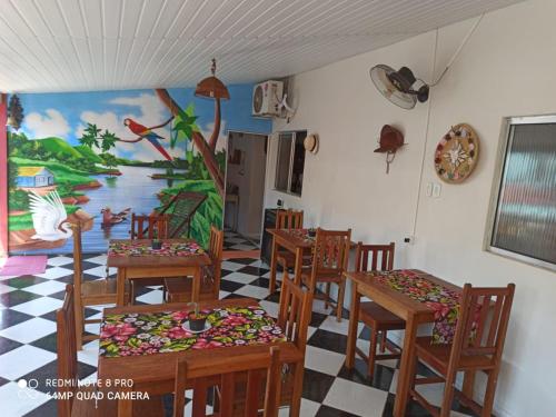een eetkamer met stoelen en een schilderij aan de muur bij Pousada Sorriso da Mata.. in Alter do Chao
