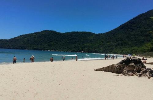 un grupo de personas de pie en una playa en Recanto da Nice, en Paraty