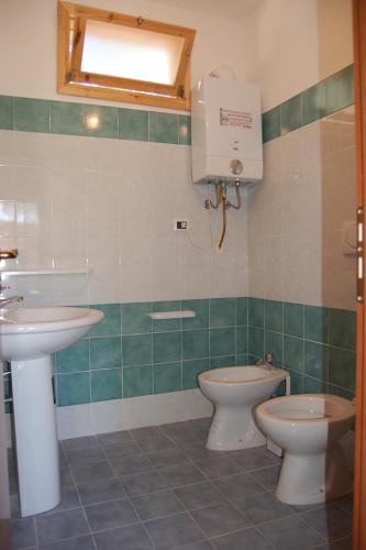 a bathroom with a sink and a toilet and a window at MIMOSA CAMPING in Isca sullo Ionio